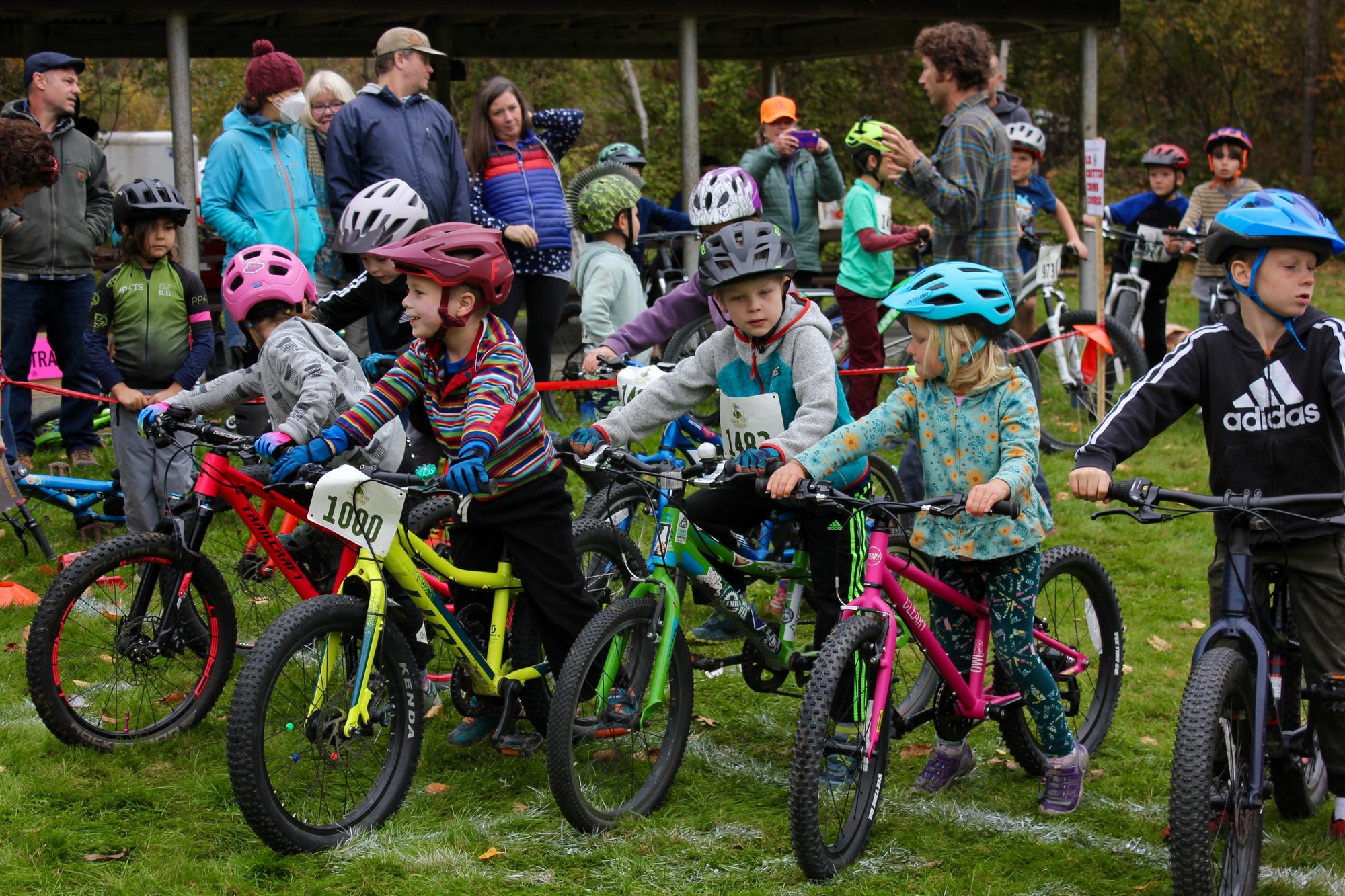 Seven kids lined up with their bikes for a cyclocross race
