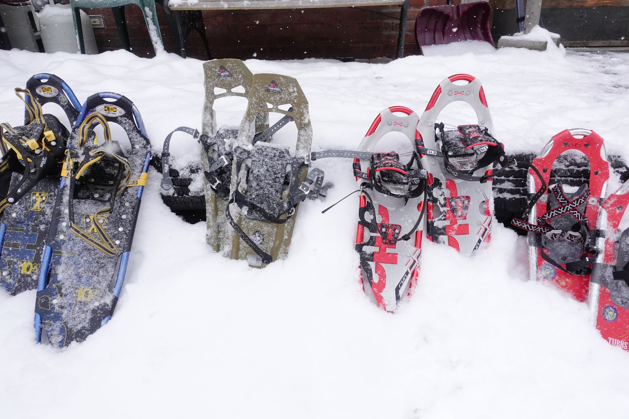 Four pairs of snowshoes resting in the snow