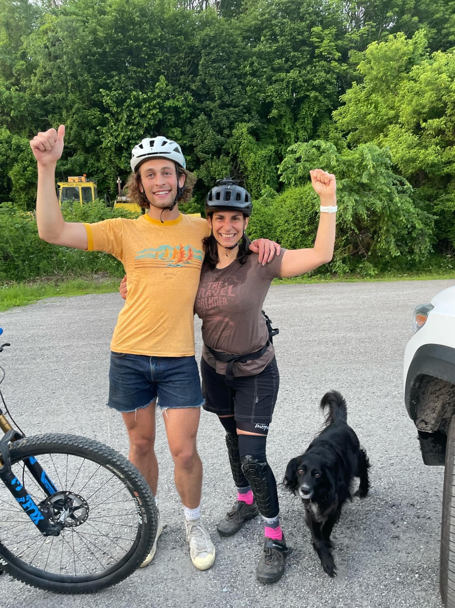 two people standing with their hands up after a mountain bike rider