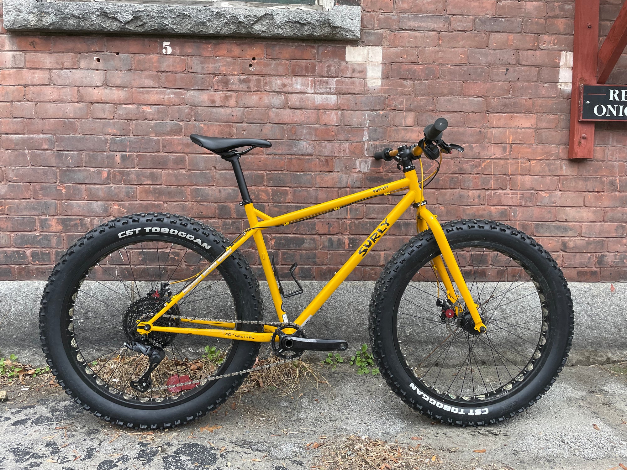 A Surly Pugsley Fat Bike leaning up against a brick wall